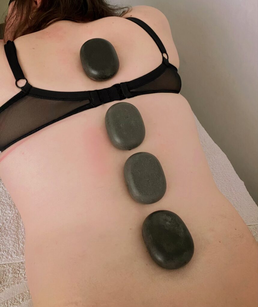 Lava massage stones shown placed on a woman's back